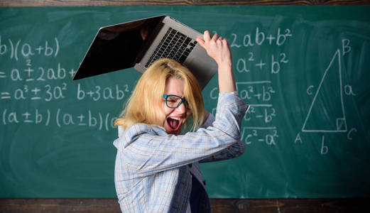 神经系统的致使。女教师举起笔记本电脑准备销毁。她需要药片来保持镇静和精神健康。教师的工作条件导致神经系统疾病