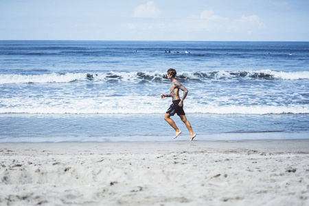 海洋海岸上的一个男人正在从事运动，在海滨跑步。 岸上运动的概念。