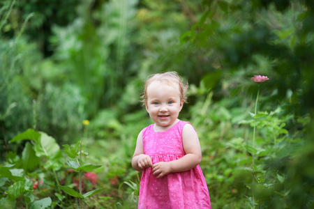 夏日花园中可爱的小女孩花的肖像