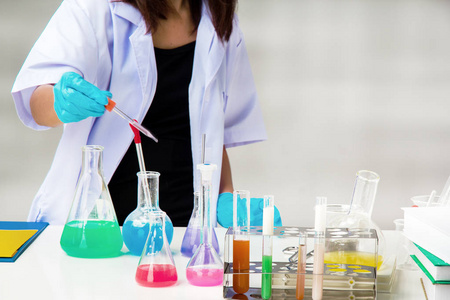 实验室使用试剂的试管做防护眼镜的化学家，接触科学试管时戴蓝色橡胶手套保护手。科学实验