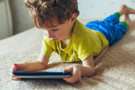 蹒跚学步的孩子盯着平板电脑。 教育电子产品依赖技术成瘾儿童视力教育儿童观念
