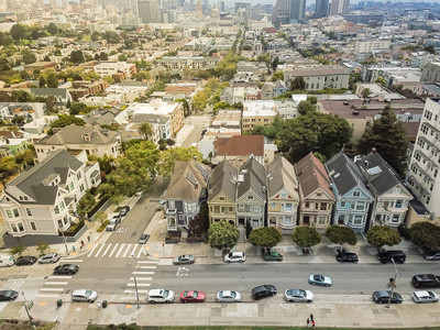 鸟瞰西部加法社区与典型的维多利亚式住宅在旧金山加利福尼亚。 从阿拉莫广场鸟瞰市中心的天际线建筑背景