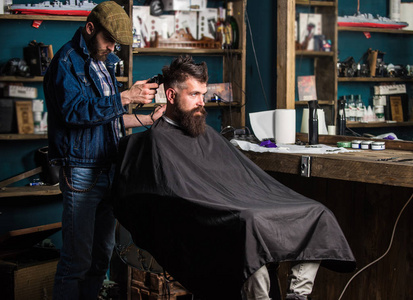 理发师与剪刀修剪头发在客户的颈背。时髦的客户得到理发。理发师理发剪头发胡子的家伙, 理发店的背景。时髦风格概念