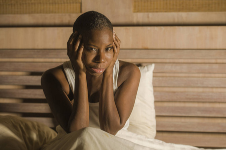 年轻的悲伤和沮丧的黑人非裔美国妇女在床上失眠，深夜感到绝望，看上去担心和焦虑，患有抑郁问题和失眠睡眠障碍