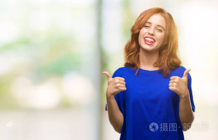 年轻漂亮的女人在孤立的背景上成功的标志做积极的手势用手竖起大拇指