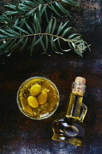 玻璃和罐子中橄榄油在破旧表面的俯视图