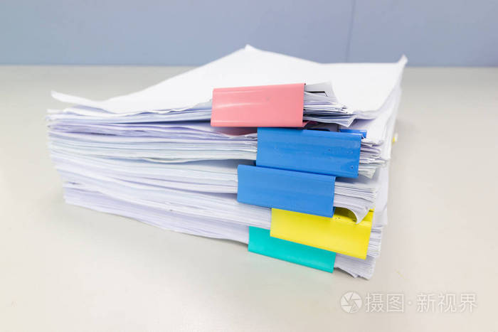 将文件文件堆放在档案文件中办公室办公桌上有回形针商业概念