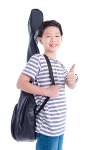 年轻的亚洲男孩，带着吉他袋微笑，在白色背景上出现拇指