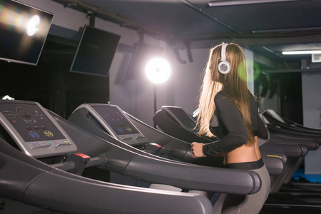 年轻的体育妇女正在健身房锻炼。在跑步机上做心肺训练