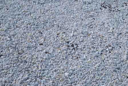 小白矿物岩石背景。在阳光明媚的日子里砾石石。街道上的装饰元素