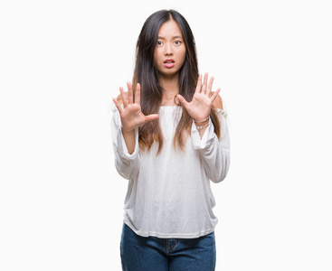 年轻的亚洲女人在孤立的背景下害怕和恐惧的表情停止手势，用手在震惊中喊叫。 恐慌的概念。
