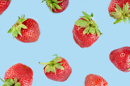 在蓝色背景上分离出的新鲜红色草莓。夏日浆果。健康饮食的概念..
