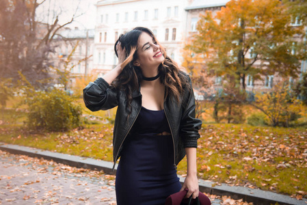 年轻的时尚女性穿着休闲服和黑色皮夹克在城市背景秋季肖像。 时髦女孩在街上摆姿势。 时髦的长发模特穿着优雅的秋装。 文泰德帽子。