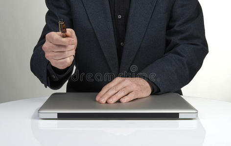一个拿着手提电脑指着笔的商人