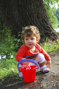 夏天河边的小女孩在玩一桶水