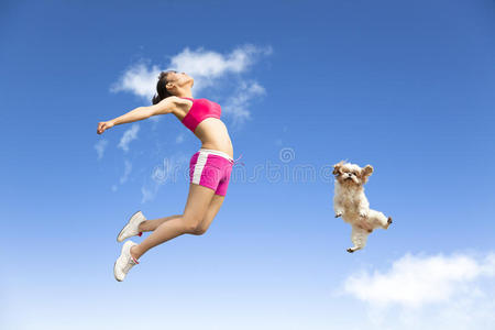 年轻女子和小狗在空中跳跃