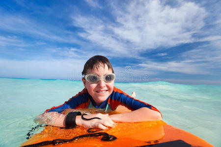 男孩在冲浪板上游泳图片