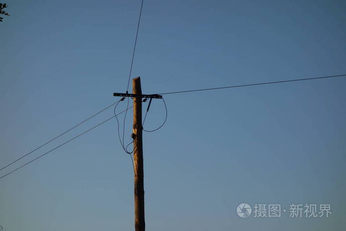 蓝天上的电线杆和电缆