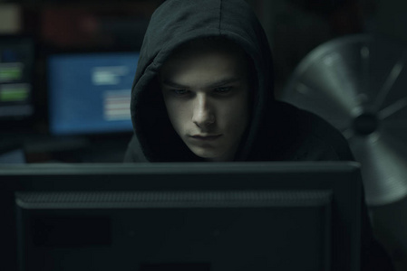 酷年轻的黑客与帽衫工作计算机网络犯罪和数据安全概念