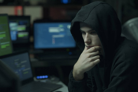 酷年轻的黑客与帽衫工作计算机网络犯罪和数据安全概念
