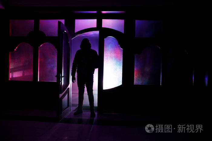 一个未知的影子在一扇门上的轮廓通过一扇封闭的玻璃门.