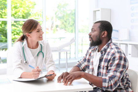年轻医生在医院和非裔美国人病人说话