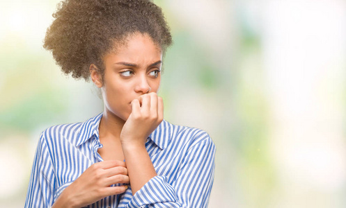 年轻的非洲美国妇女在孤立的背景上看起来压力和紧张，双手咬着嘴的指甲。 焦虑问题。