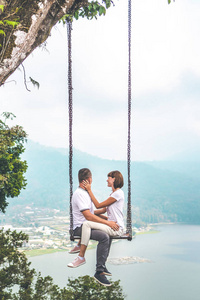 年轻的蜜月情侣在丛林中摇摆在湖附近, 巴厘岛, 印度尼西亚