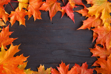 秋季框架构图，落叶在木制背景上，有文字的复制空间。 感恩节万圣节季节性秋季概念平面