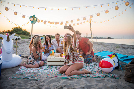 一群朋友在海滩野餐，快乐的年轻人在海滩度假