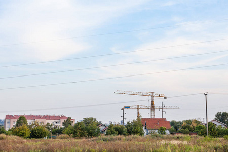 belgrade郊区的近郊城市风光，在田野中间的一个建筑工地上有起重机，背景中可见新的分隔建筑