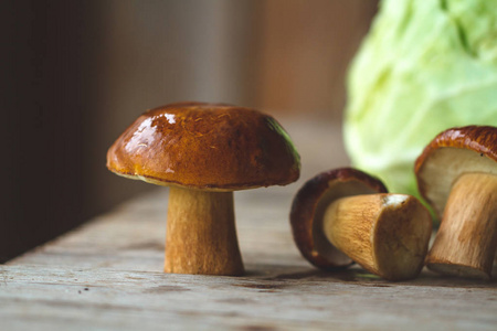 木桌上放着绿色卷心菜的森林蘑菇