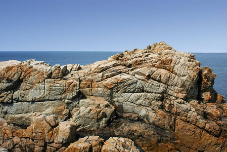 蓝天背景下的带海的岩石海岸线