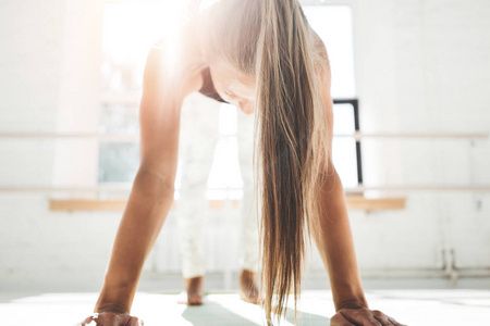 适合年轻的运动女性做锻炼，以改善她的腹肌在阳光明媚的白色口香糖在早上。 体育运动的女人在健身房做交叉健身运动