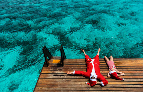 圣诞节圣诞老人和小女孩享受圣诞节旅行假期热带海洋