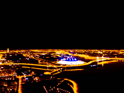 一个大城市的抽象模糊背景空中夜景。 城市景观全景在晚上。 夜间用汽车模糊地俯瞰摩天大楼和道路。 从上面模糊顶部视图。 布克光
