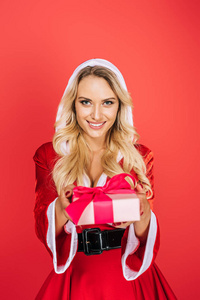 微笑的圣诞老人女孩圣诞礼服礼品盒隔离红色背景