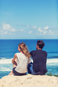 一对夫妇在热带海滩上欣赏风景。