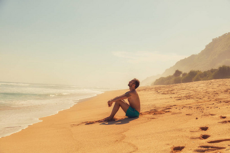 男人在空荡荡的热带异国海滩上享受。