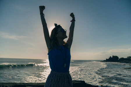 女孩张开双臂享受海洋。