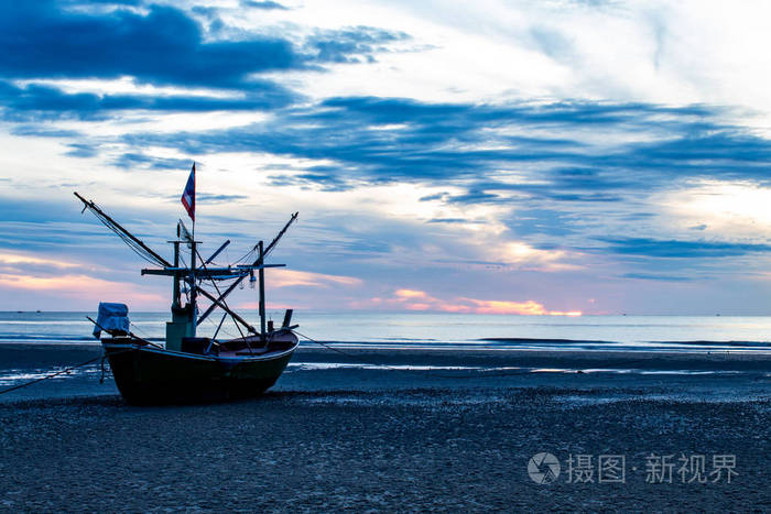 清晨的阳光照耀着大海,船在海滩上.