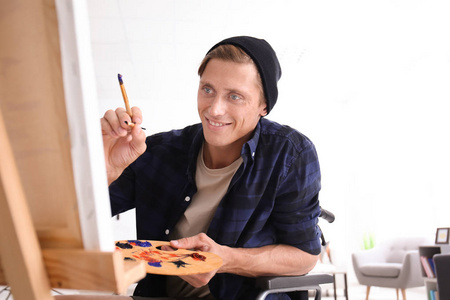 坐轮椅的年轻艺术家在家中绘画