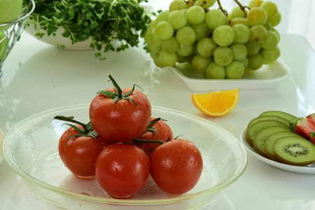 新鲜的红西红柿，番茄皮上有水滴。与各种生有机蔬菜混合。 排毒饮食与各种有机蔬菜和水果的组合。 均衡饮食。