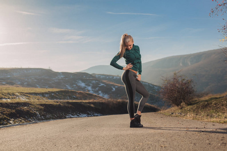 年轻的健身妇女在山顶上锻炼