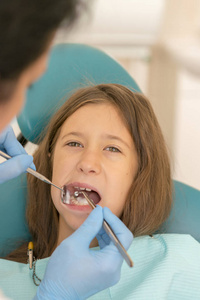 s . little girl sitting in a chair near a dentist after de