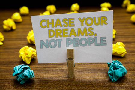 写笔记显示追逐你的梦想, 而不是人。商业照片展示不跟随别人追逐目标目标书面记事本立场与回形针黄色蓝色 lob 在木甲板上