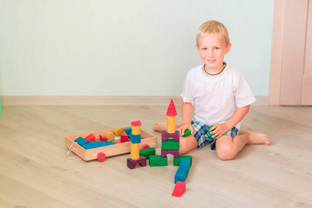 可爱的小男孩在房间里玩彩色木块。 早期发展概念