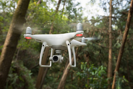 白色无人机，相机飞越森林