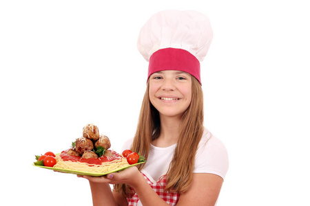 快乐的女孩用意大利面和肉丸做菜