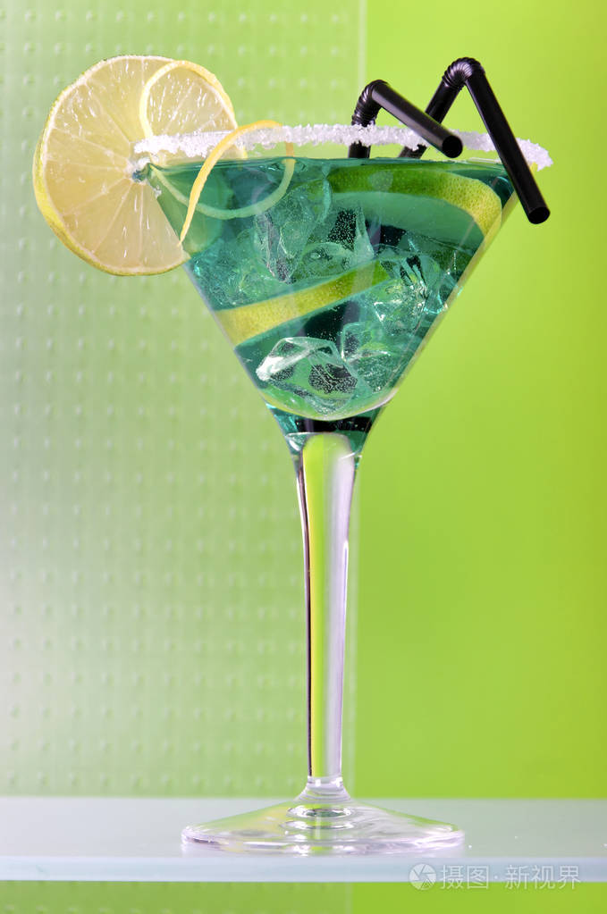马提尼杯中的绿色鸡尾酒配以石灰片和糖